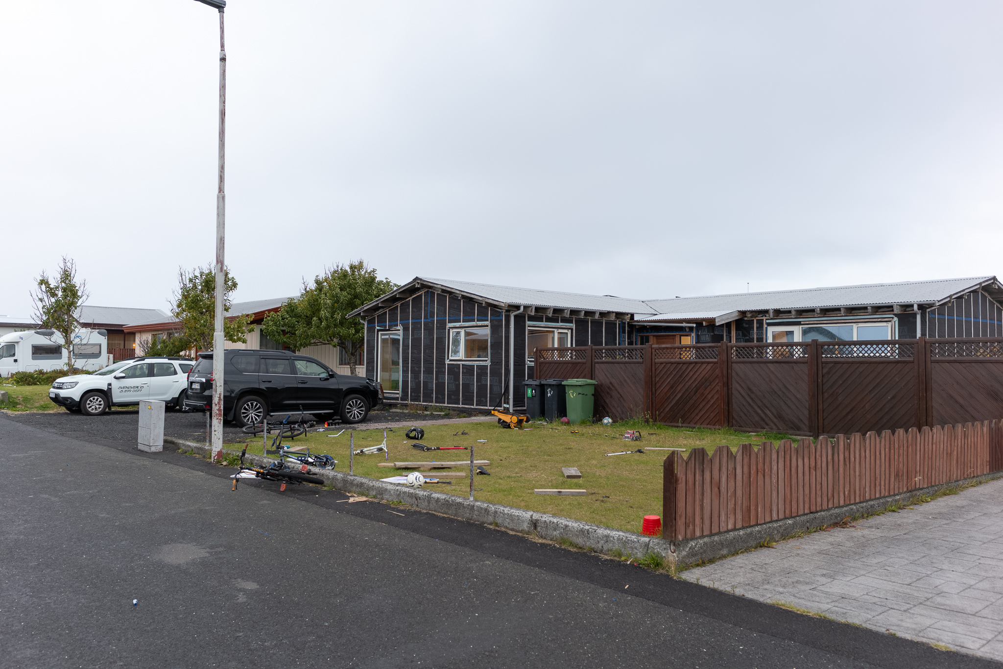 Holzhaus in Njarðvík Dunkles Holzhaus mit Vorgarten an einer Straße in Njarðvík