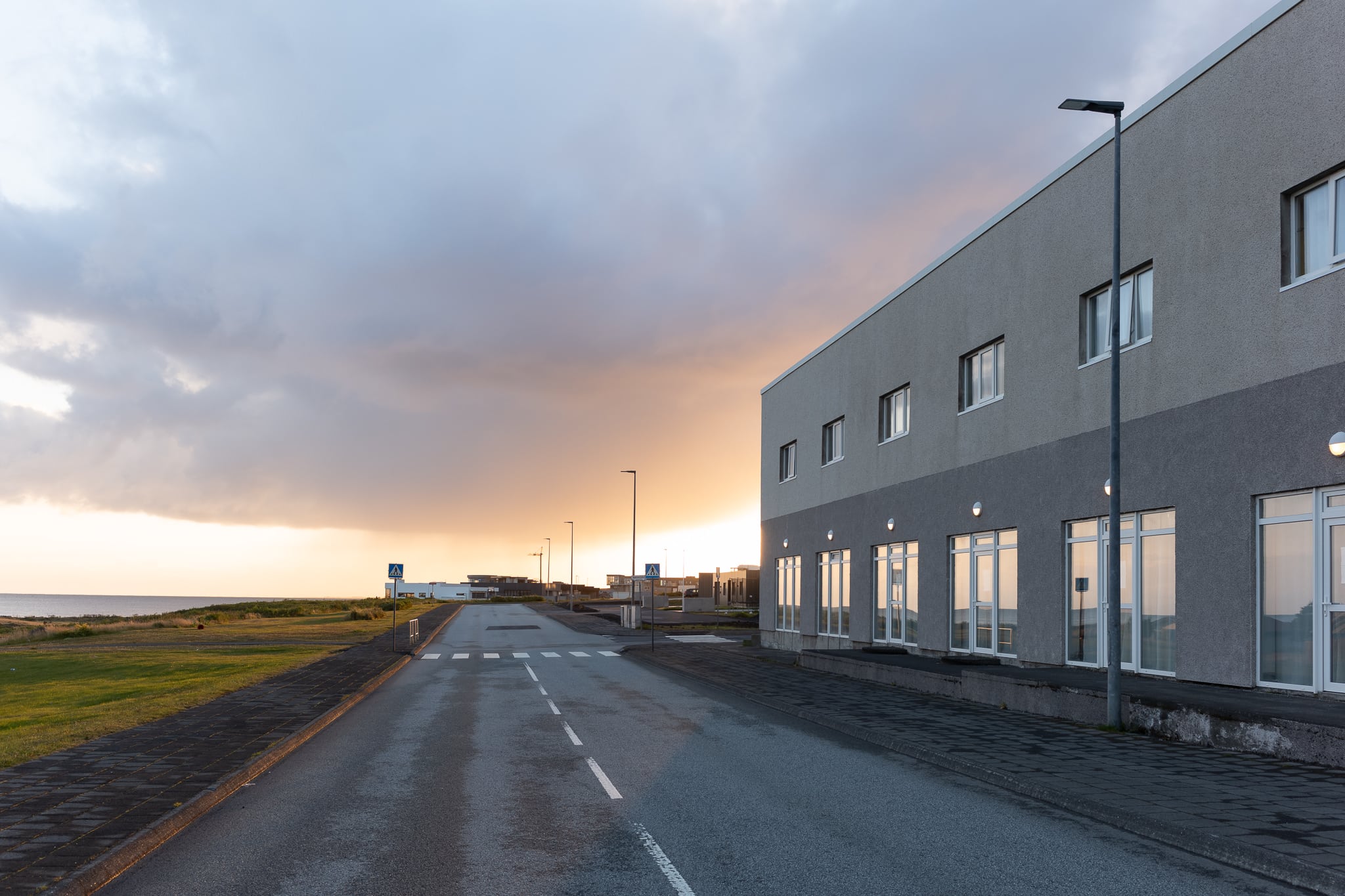 Neubau in Njarðvík Zweckbau mit grauer Fassade an einer Straße in Njarðvík im Abendlicht. Im Gebäude befindet sich auch das Hotel Tjarna.