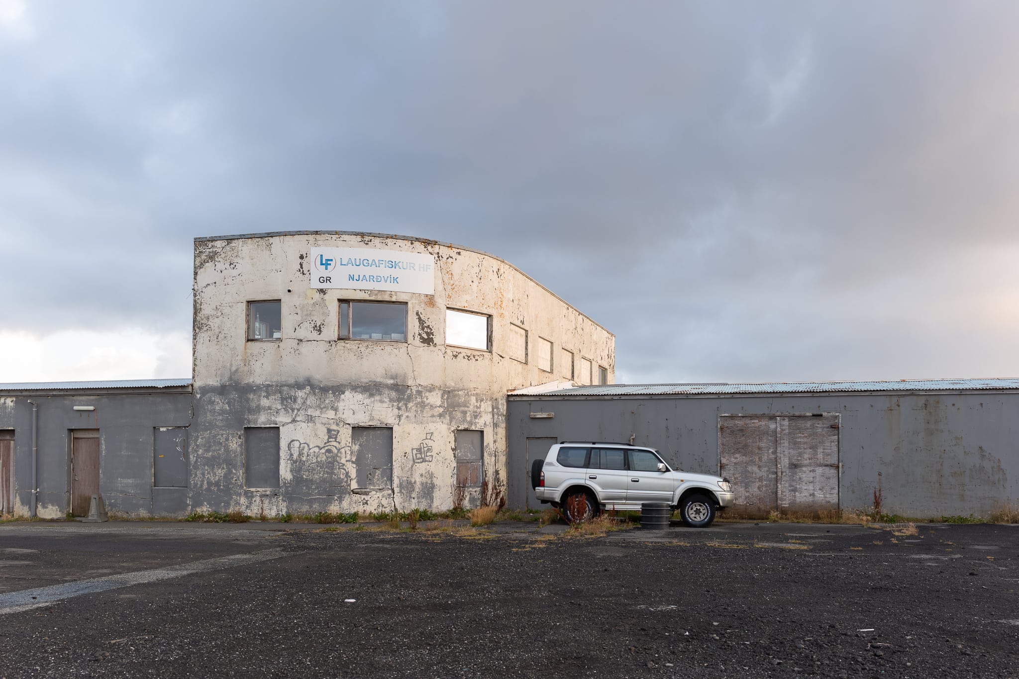 Altbau in Njarðvík Älteres Gebäude mit runder Fassade hinter einer Mauer in Njarðvík