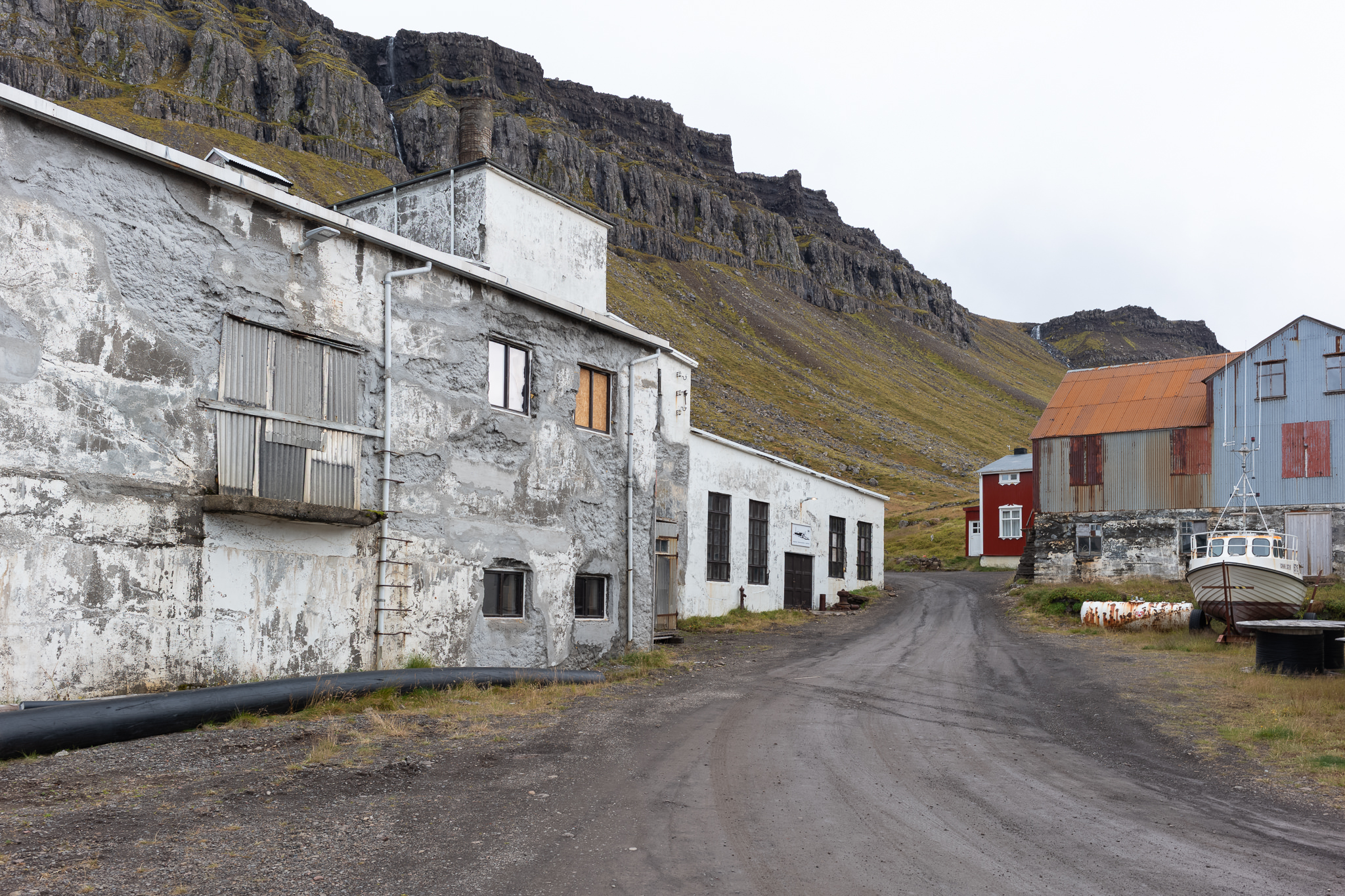 Straße in Djúpavík Verwitterte Fabrikgebäude und Wohnhäuser an der Straße in Djúpavík